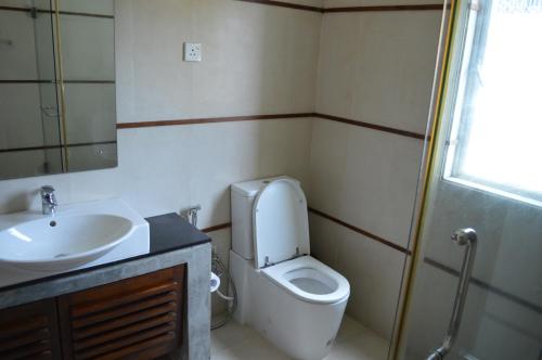 a bathroom with a white toilet and a sink at Star Class Comfort in Capital City in Battaramulla