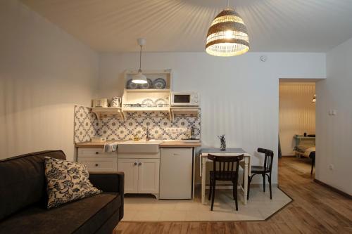eine Küche und ein Wohnzimmer mit einem Tisch und einem Sofa in der Unterkunft Egyszervolt Házikó in Tiszafüred