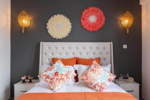 a bedroom with a white bed with pillows and mirrors at 373 Wolmar Cosy and Modern Apartment- 200 metres from the Beach and Supermarkets and just next to Domaine de wolmar with views of deers and green natural park in Flic-en-Flac