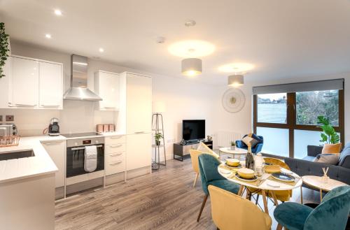 The Arches Watford Serviced Apartment في واتفورد: مطبخ وغرفة معيشة مع طاولة وكراسي