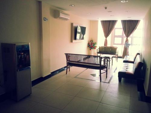 a living room with a bench and two chairs at Hotel Centre Point Tampin in Melaka