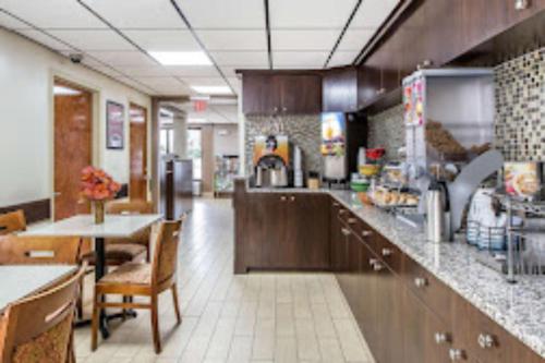 uma cozinha com um balcão, uma mesa e cadeiras em Econo Lodge Midtown em Savannah