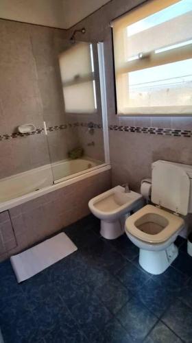 een badkamer met een toilet, een bad en een wastafel bij Duplex Boulevard A in Viedma
