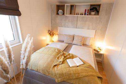 a bedroom with a large bed with two books on it at gemütliches, voll ausgestattes Tiny House in Vilseck