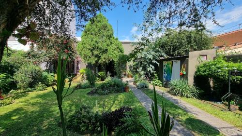 un jardín con un árbol y un edificio en Yunga en Salta