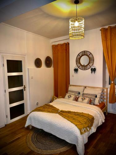 a bedroom with a large bed and a chandelier at Bohème Spa Appartement privatif avec jacuzzi in Orléans