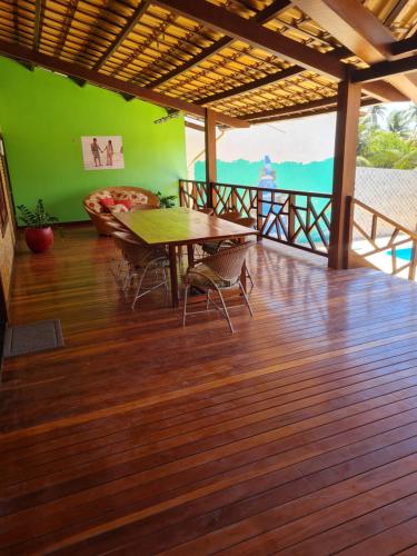 comedor con mesa y sillas en un suelo de madera en Casa Grande de Férias, en Uruaú