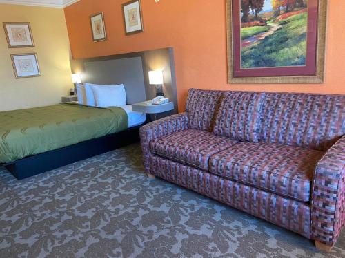 a hotel room with a couch and a bed at Quality Inn & Suites Galveston - Beachfront in Galveston