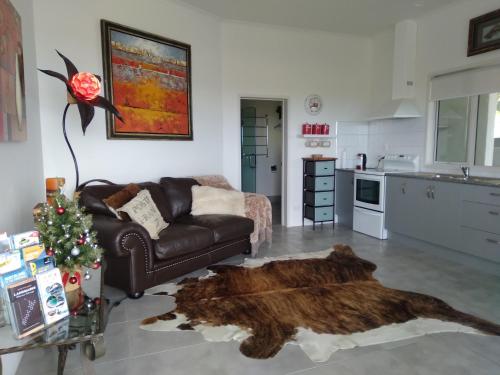 a living room with a leather couch and a fur rug at Taipa Coastal Retreat in Taipa