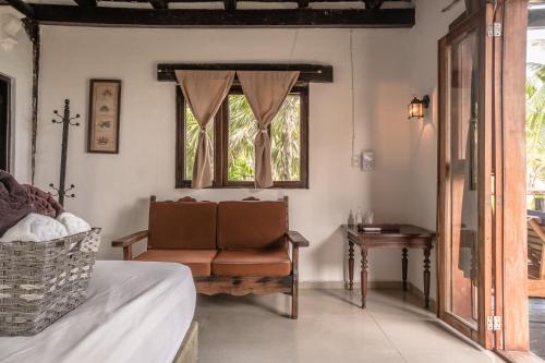 a bedroom with a chair and a window at Playa Esperanza Tulum in Tulum