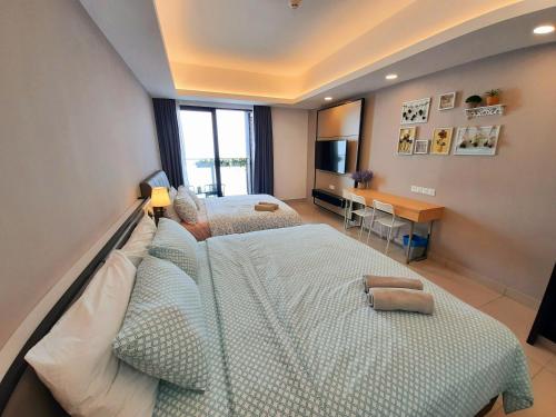 a bedroom with two beds and a desk and a television at Studio Above The Cloud at Ion Element Genting in Genting Highlands