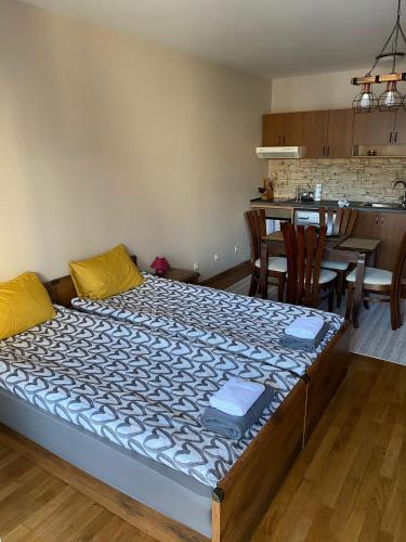 a large bed in a room with a kitchen at Bansko SPA Studio at Predela1 in Bansko