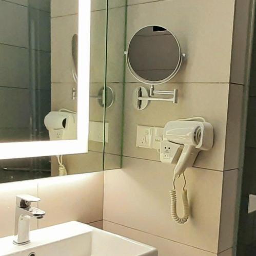 a bathroom with a sink and a mirror and a phone at Studio Above The Cloud at Ion Element Genting in Genting Highlands