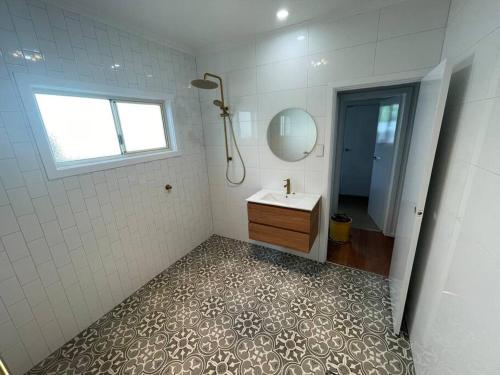 een badkamer met een wastafel en een spiegel bij House on Argent Street in Broken Hill