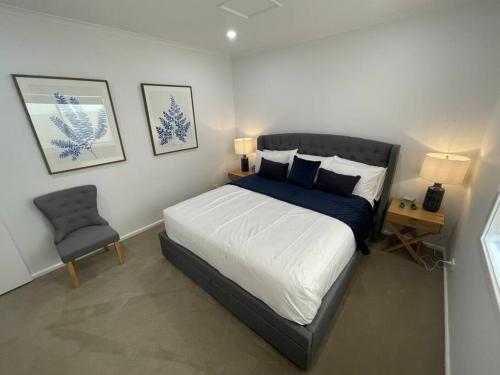 una camera con un grande letto e una sedia di House on Argent Street a Broken Hill
