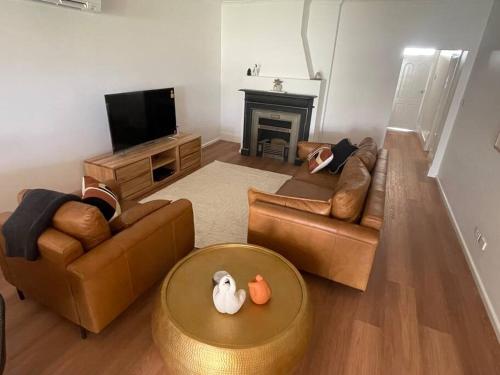 a living room with two couches and a television at House on Argent Street in Broken Hill