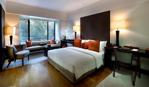 a bedroom with a bed and a desk and a chair at The Saujana Kuala Lumpur in Subang Jaya