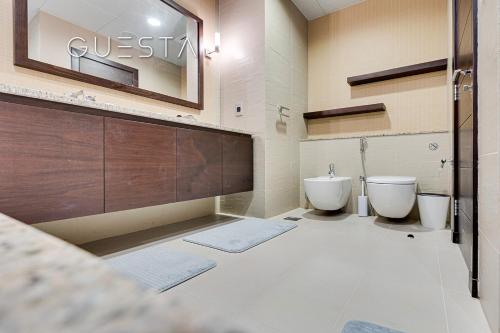 a bathroom with two sinks and two toilets at Tiara Residences, Free beach & pool access in Dubai