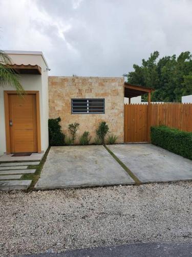 una pequeña casa con una puerta y una valla en Maison chaleureuse avec Jacuzzi ! en Punta Cana