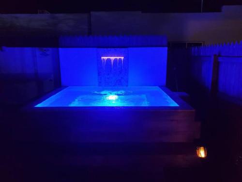 a dark room with a tub with blue lights at Maison chaleureuse avec Jacuzzi ! in Punta Cana