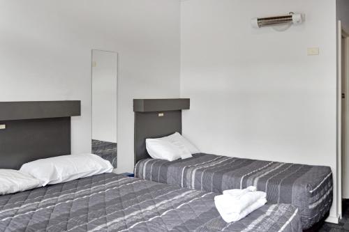 two beds sitting next to each other in a room at Central Wangaratta Motel in Wangaratta
