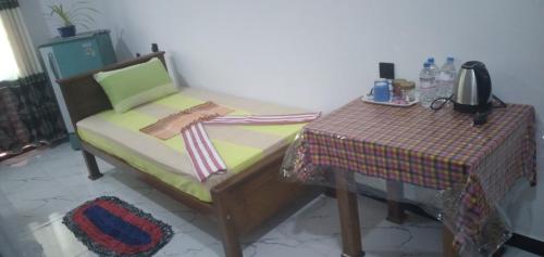 a bed and a table in a room at Resort of Happiness in Mirissa