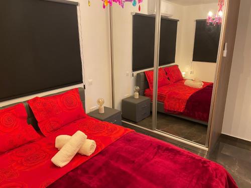 a red bedroom with two beds and a mirror at SOFROS VALLEY HILLS CHALET in Ayios Mamas