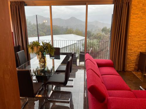 a dining room with a table and red chairs at SOFROS VALLEY HILLS CHALET in Ayios Mamas