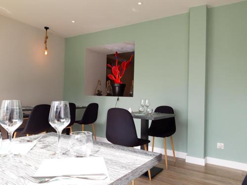 a dining room with chairs and a table with wine glasses at L'Expression in Saint-Jean-de-Marsacq