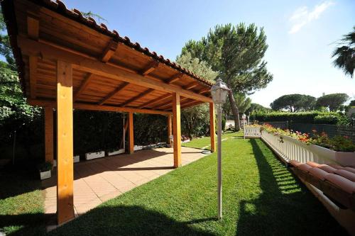 a wooden pergola in a park with a bench at Villa Axa in Casal Palocco