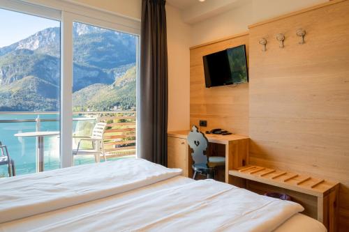 a hotel room with a bed and a window at Hotel Fontanella in Molveno