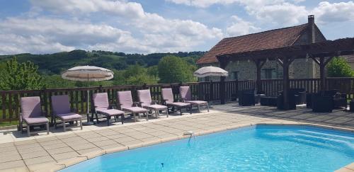 - un groupe de chaises assises à côté de la piscine dans l'établissement Meadow View Gîtes - Grande gîtes, piscine, wi-fi - Janaillat, Creuse, France, 23250, à Janaillat