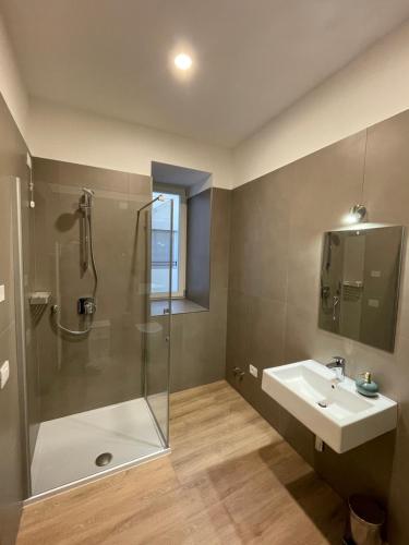 ein Bad mit einer Dusche und einem Waschbecken in der Unterkunft Al Palazzo in Cles