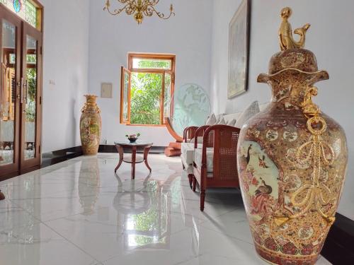 a living room with a large vase on the floor at Griya Asih in Yogyakarta