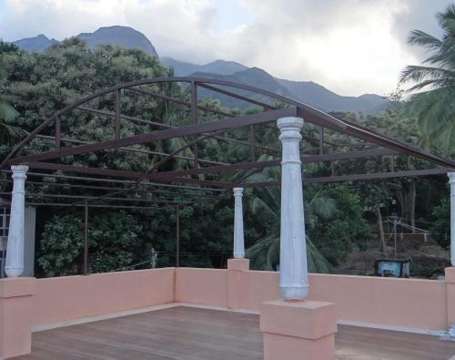 un puente sobre una terraza con montañas al fondo en Laughing Waters Fine Stay, en Kuttālam