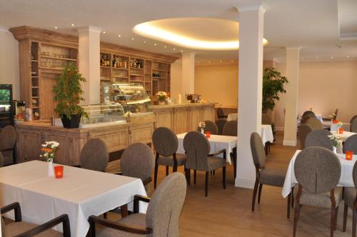 a restaurant with tables and chairs and a counter at Hotel Karl's Burg in Kölpinsee
