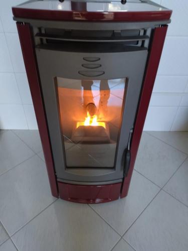a stove with a fire in it sitting on a floor at Nonno Ciccio Apartment in Lizzano