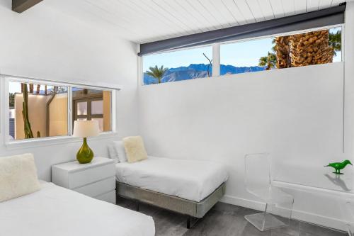 a bedroom with two beds and a sink and a window at Happy Hour in Palm Springs