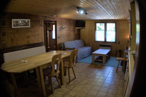 - une chambre avec une table, des chaises et un canapé dans l'établissement CHARMIEUX appartement en chalet typique, au Grand-Bornand