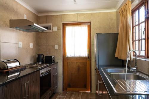 una pequeña cocina con fregadero y ventana en De Hollandsche Molen en Hou Moed