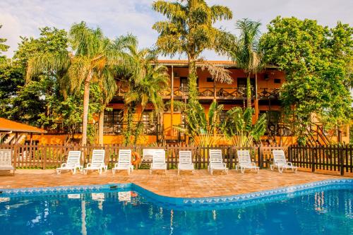a resort with chairs and a swimming pool at Pousada Canto Grande in Bombinhas
