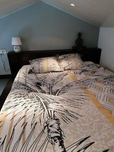 een groot bed in een slaapkamer met een sprei erop bij Le repos chavagnais in Chavagnes-en-Paillers