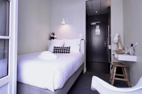 - une chambre avec un grand lit blanc et un lavabo dans l'établissement Zcube Andaman, à Port Blair