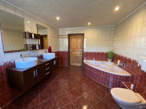 a bathroom with two sinks and a tub and a toilet at Ferienhaus Victoria in Schwarzheide