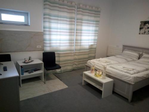a bedroom with a bed and a table and a chair at Hunedoara Sport Confort in Hunedoara