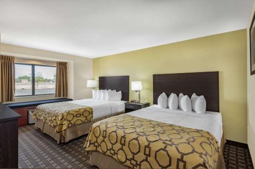 a hotel room with two beds and a window at Baymont by Wyndham Farmington in Farmington