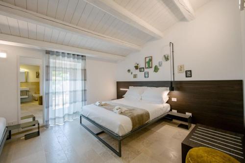 um quarto com uma cama grande e uma janela grande em IBLA ROOMS em Ragusa