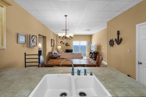 a kitchen with a sink and a living room at Sans Souci unit 706 in Pensacola Beach