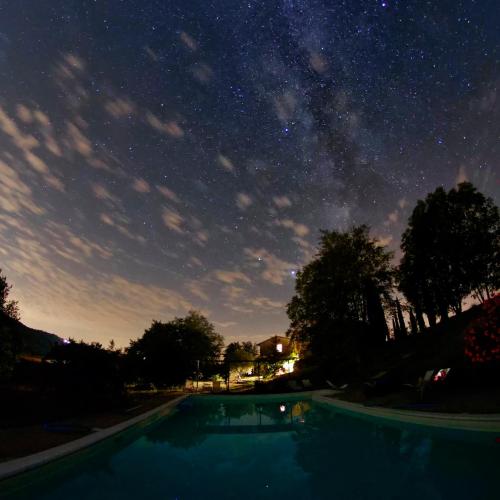 a starry sky over a swimming pool at night at Agriturismo Casa Greppo in San Venanzo