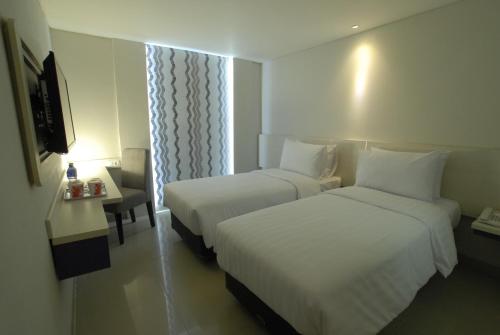 a hotel room with two beds and a window at Vio Veteran in Bandung